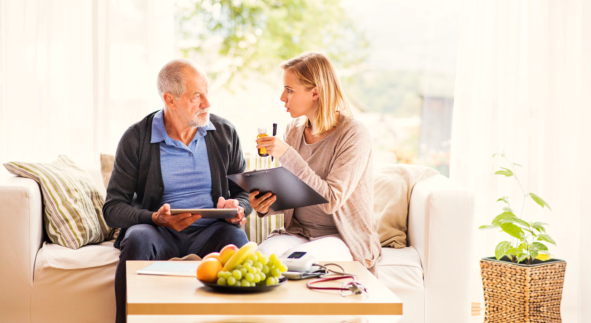 careviver explaining to senior man about his medications